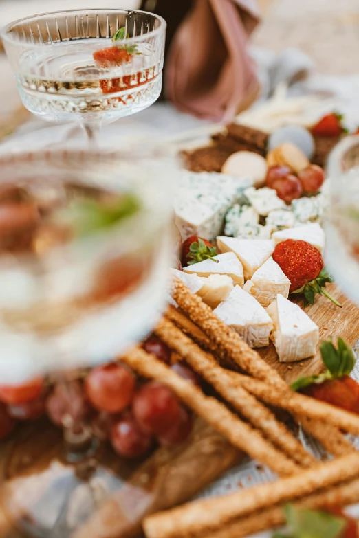 a close up of a plate of food on a table, bubbly, cheeses, glassware, upclose