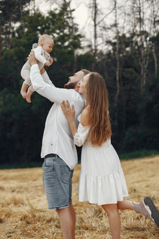 a man and woman holding a baby in a field, pexels contest winner, russian girlfriend, wearing white clothes, square, very tall