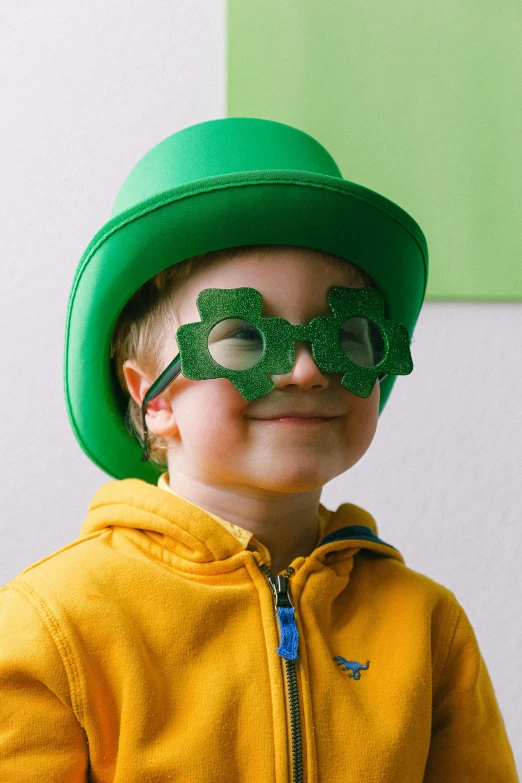 a young boy wearing a green hat and glasses, clover, green and gold, very excited, sustainability