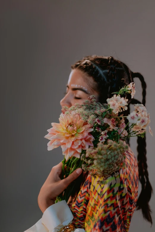 a woman holding a bunch of flowers in her hands, an album cover, trending on unsplash, hyperrealism, aida muluneh, girl with plaits, high quality photo, embracing