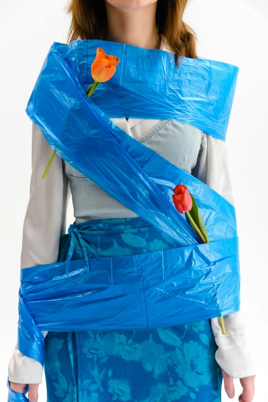 a woman wearing a blue wrap around her body, an album cover, by Jesús Mari Lazkano, reddit, plasticien, restrained. bloom, recycled, tulip, contest winner 2021