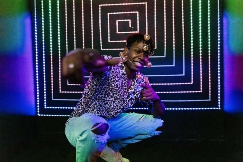 a man sitting on the ground in front of a colorful wall, by Lily Delissa Joseph, unsplash, afrofuturism, jeweled costume, he is casting a lighting spell, chief keef, made of dots