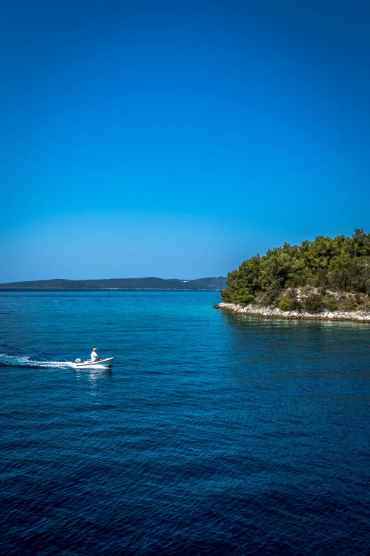 a small boat in the middle of a large body of water, by Daren Bader, croatian coastline, slide show, tubing, f/2