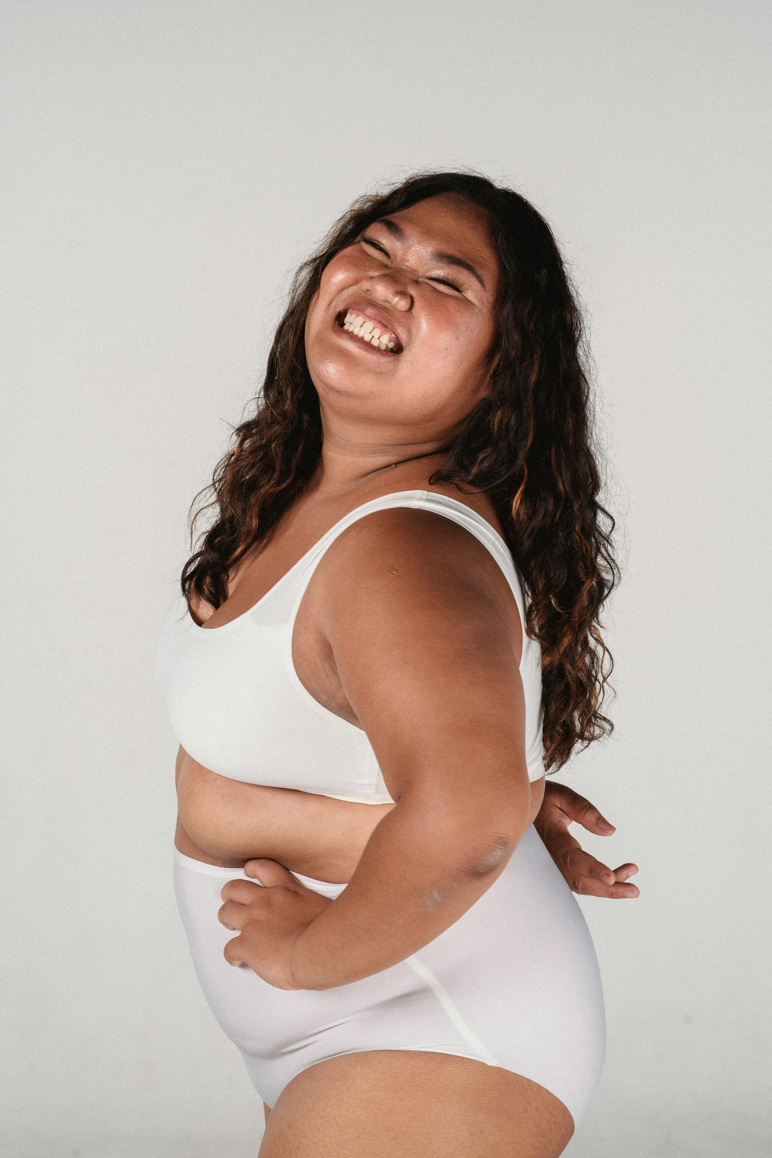 a woman in a white underwear posing for a picture, laughing maniacally, slightly fat, wearing a cropped tops, portrait featured on unsplash