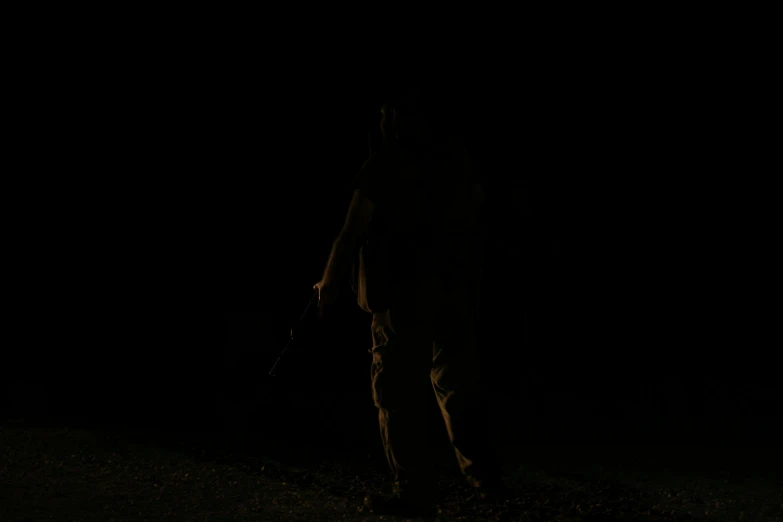 a man standing in the dark holding a frisbee, carrying a rifle, walking away from the camera, profile picture 1024px, zoomed out full body