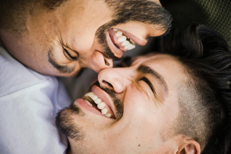 a couple of men laying on top of each other, trending on pexels, all teeth, close up half body shot, lgbt, brown