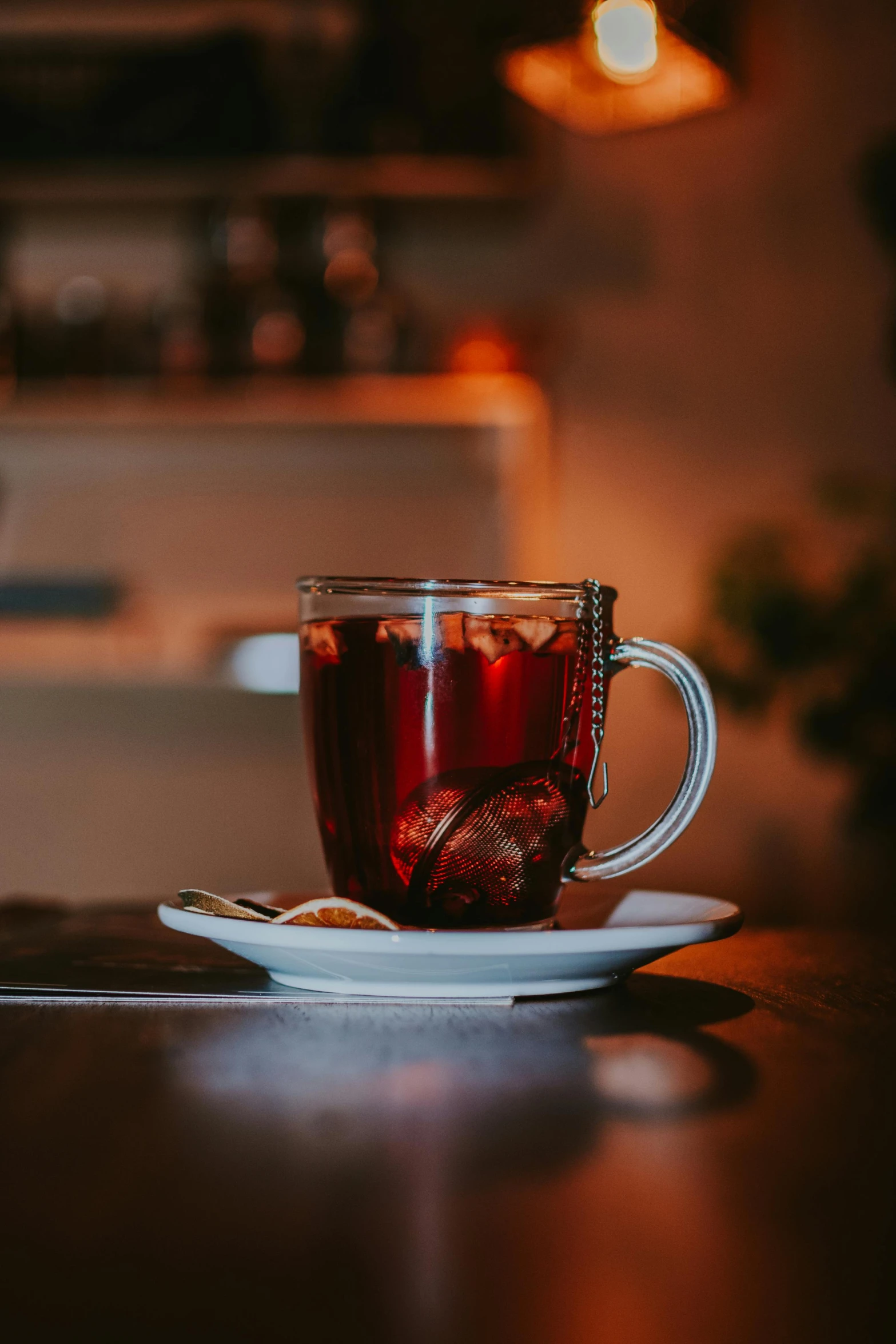 a cup of tea sitting on top of a table, by Jesper Knudsen, pexels contest winner, renaissance, dark red, cozy cafe background, full-body, sparkling