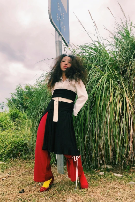 a woman standing in front of a street sign, an album cover, inspired by Tadashige Ono, renaissance, black red white clothes, wide leg hakama trousers, willow smith young, red waist-long hair