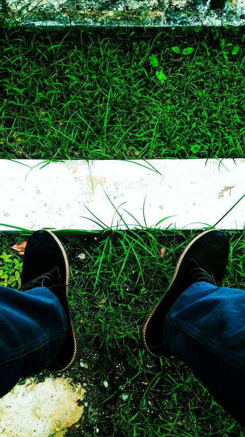 a person standing on top of a grass covered field, an album cover, by Adam Chmielowski, unsplash, storm drain, sit on a bench, marking lines, white shoes