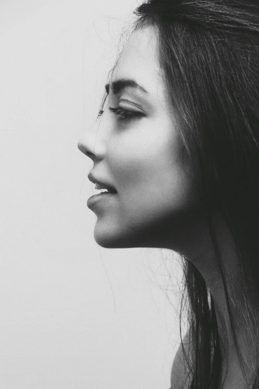 a black and white photo of a woman with long hair, inspired by irakli nadar, strong jawline, smiley profile, she has olive brown skin, & her expression is solemn