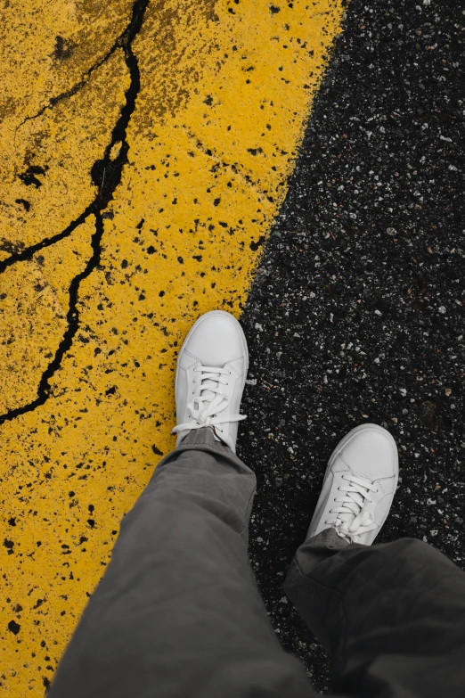 a person standing in the middle of a street, trending on pexels, yellow and charcoal leather, white shoes, an all white human, on a landing pad