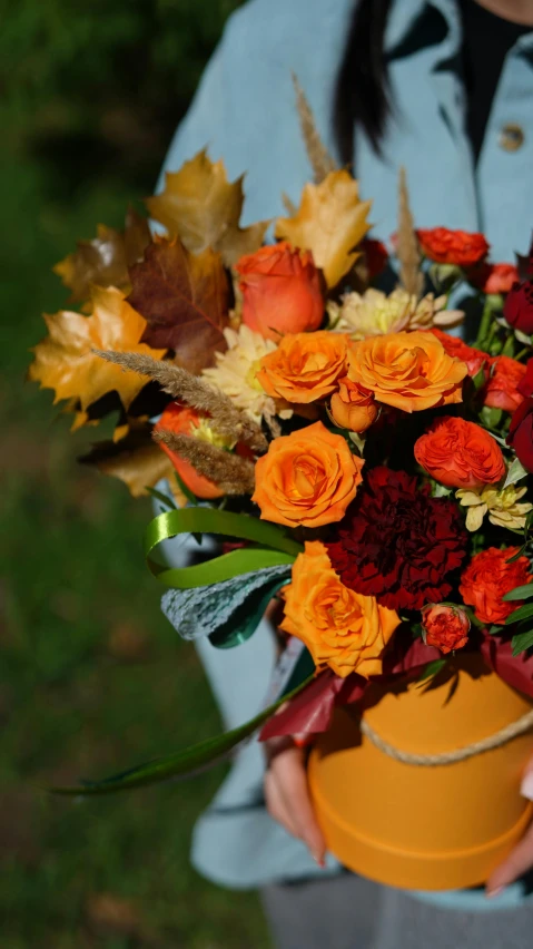 a close up of a person holding a flower pot, dark oranges reds and yellows, bouquets, square, during autumn