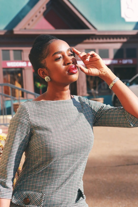 a woman standing on a street talking on a cell phone, a portrait, by Winona Nelson, pexels contest winner, african american elegant girl, blue checkerboard dress, girl with a pearl earringl, fall season