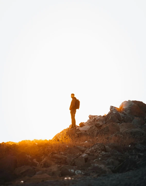 a man standing on top of a rocky hill, pexels contest winner, minimalism, full body backlight, warm glow, trending on vsco, multiple stories