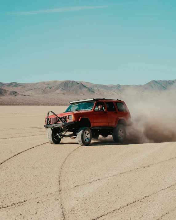 a red jeep driving through the desert on a sunny day, pexels contest winner, on a street race track, exploding powder, 90s photo, 5k