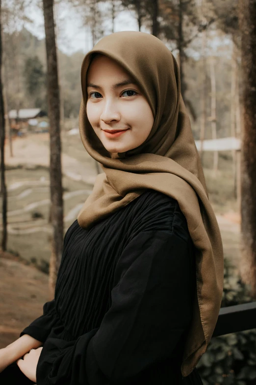 a woman wearing a hijab poses for a picture, inspired by Nazmi Ziya Güran, pexels contest winner, hurufiyya, black and brown, clean and simple, asian girl, olive