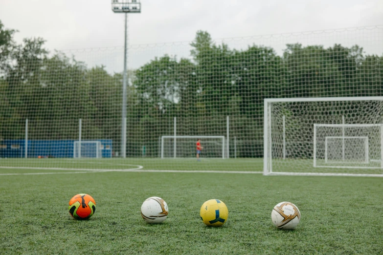 a group of soccer balls sitting on top of a field, playing