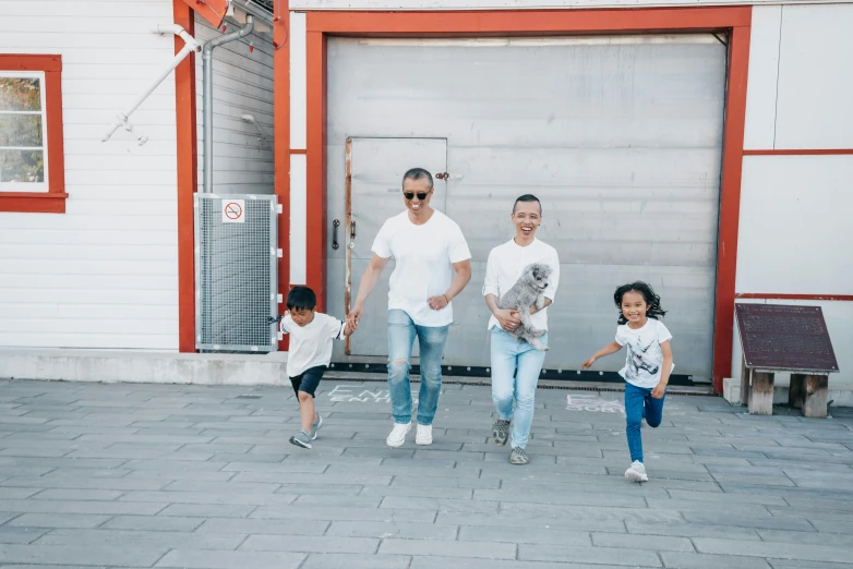 a group of people standing in front of a garage, by Julia Pishtar, pexels contest winner, happening, happy family, running freely, asian male, avatar image