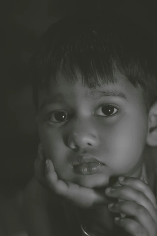 a black and white photo of a young boy, a black and white photo, pexels contest winner, jayison devadas, wistful expression, sepia toned, selective color effect