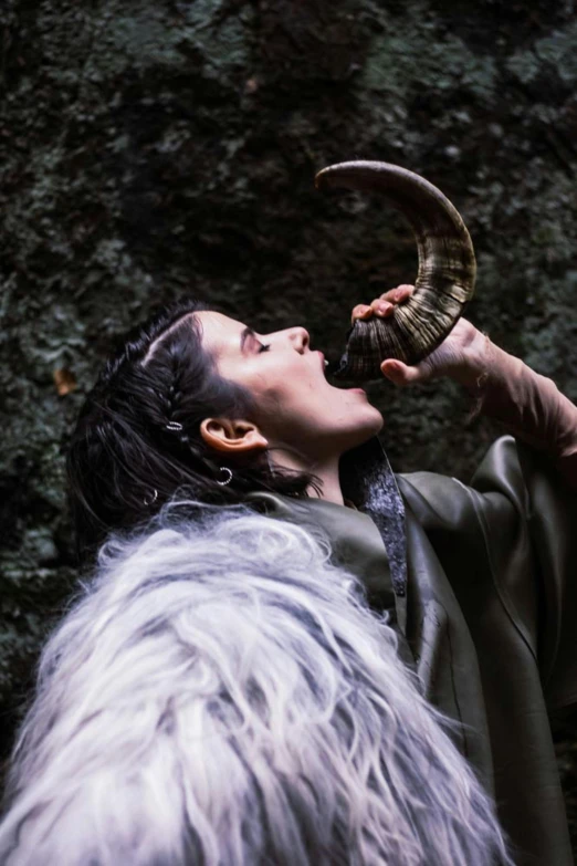 a man that is holding a horn in his hand, an album cover, inspired by Kanō Hōgai, unsplash, female druid, live action, large horned tail, rey