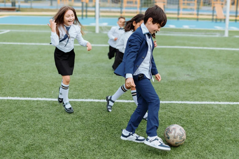 a group of young children playing a game of soccer, pexels, quito school, wearing school uniform, a handsome, girl wearing uniform, milan jozing