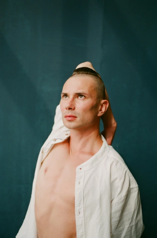 a shirtless man standing in front of a blue wall, an album cover, unsplash, bauhaus, shaved head, portrait of combat dancer, shaven, julian ope