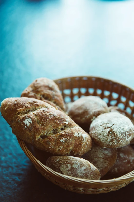 a basket of bread sitting on top of a table, crispy buns, paul barson, visually crisp & clear, granite