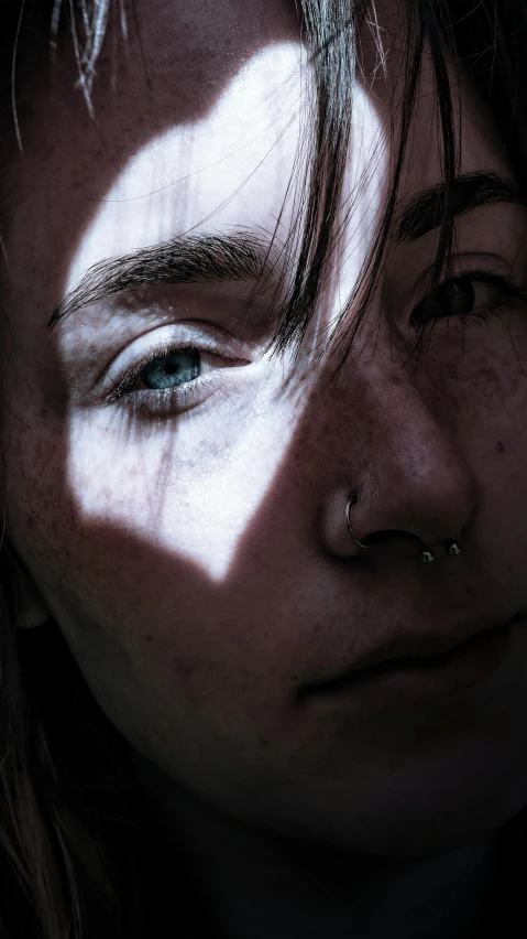 a close up of a woman with freckles on her face, an album cover, trending on pexels, hyperrealism, light over boy, cinematic chiaroscuro, young male, skydsgaard