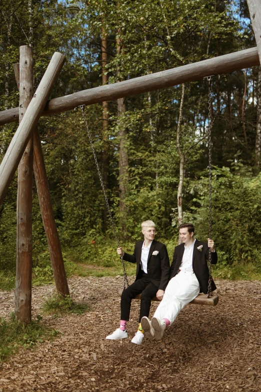 a man and a woman sitting on a swing, maarten schröder and tom bagshaw, lgbtq, espoo, tuxedo