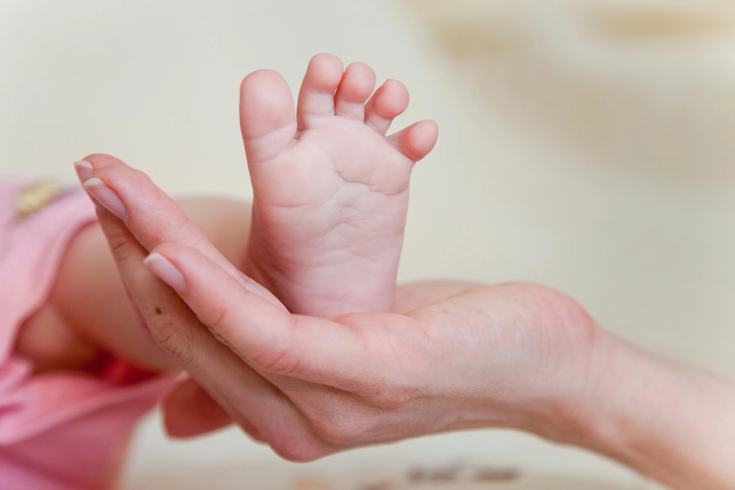 a close up of a person holding a baby's foot, different sizes, gentle face, thumbnail, mini model