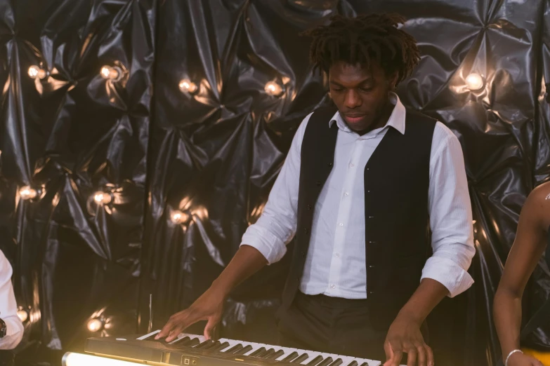 a man that is standing in front of a keyboard, inspired by Richard Wright, lights, a black man with long curly hair, recital, ignant