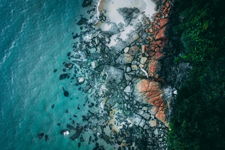 a large body of water next to a rocky shore, unsplash contest winner, bird\'s eye view, contrasting colours, manly, ((rocks))