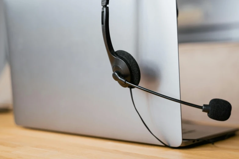 a close up of a laptop with a headset on, by Matthias Stom, trending on pexels, thick looping wires, thumbnail, bottom - view, in an call centre office