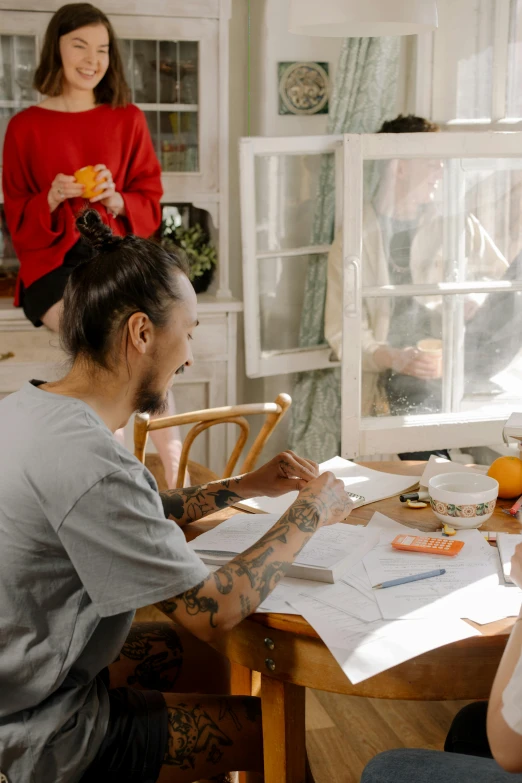 a group of people sitting around a wooden table, on kitchen table, profile image, tattooed, sketching