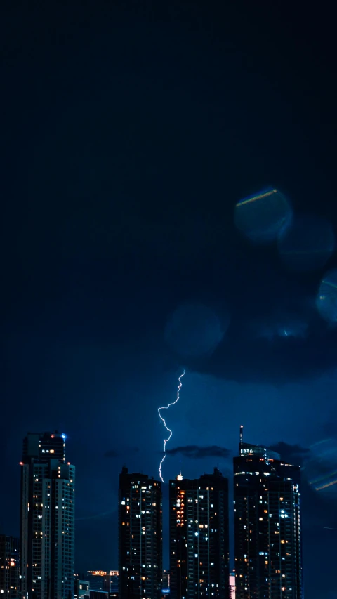 a city at night with a lightning bolt in the sky, by Jacob Toorenvliet, pexels contest winner, minimalism, dramatic blue light, cinematic shot ar 9:16 -n 6 -g, high quality photo, downpour