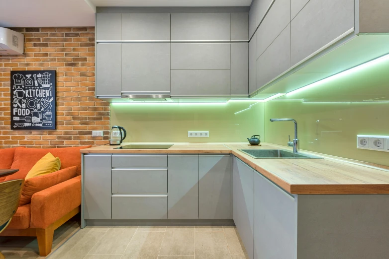 a kitchen with a couch and a table in it, a picture, by Adam Marczyński, unsplash, led light strips, grey orange, brick, soft green natural light