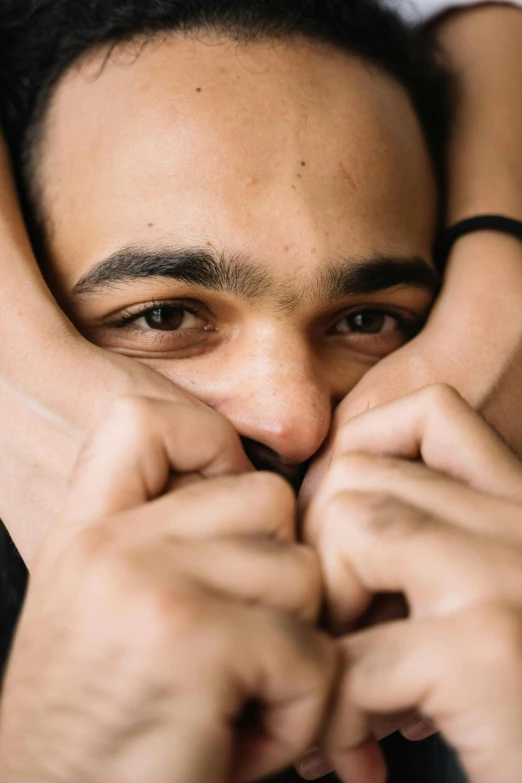 a man covering his face with his hands, a picture, trending on pexels, square masculine facial features, hugging each other, large dark eyes, high angle closeup portrait