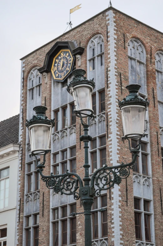 a clock that is on the side of a building, by Jan Tengnagel, art nouveau, rembrandt lighting scheme, street lamps, wind chimes