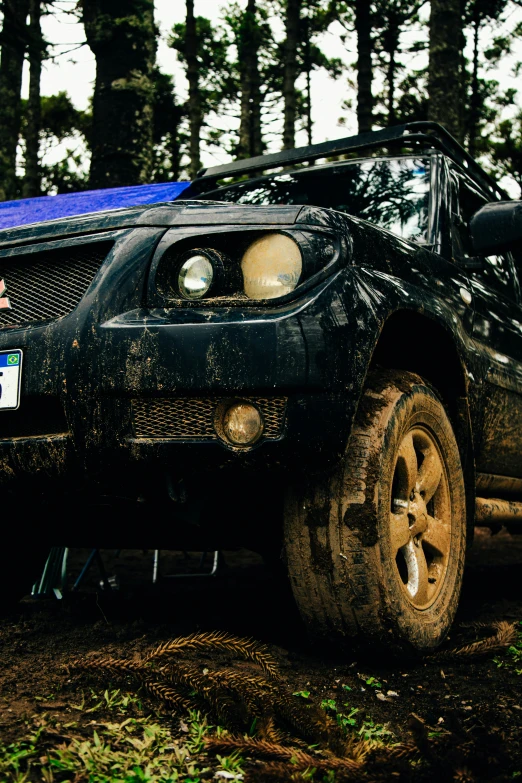 a car that is sitting in the dirt, by Adam Marczyński, unsplash, her face muddy and sweat, rugged ranger, blue headlights, in a jungle environment