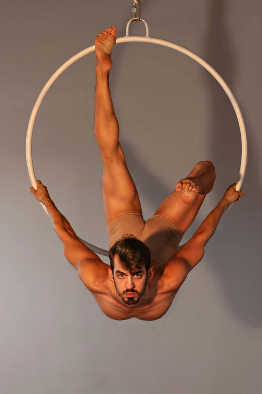 a man hanging upside down on a ring, by Julian Allen, arabesque, male aeromorph, mid-shot of a hunky, circular, juan jose serrano