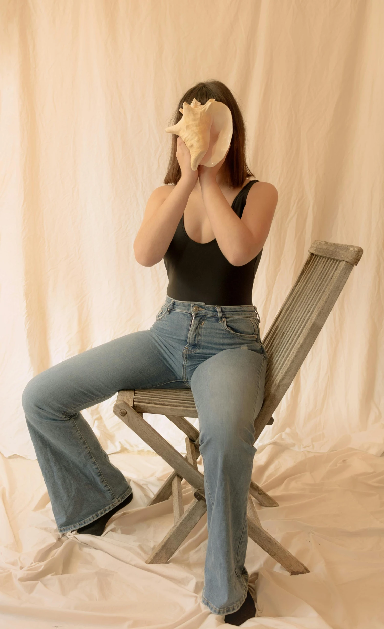 a woman sitting on top of a wooden chair, inspired by Sarah Lucas, pexels contest winner, renaissance, jeans pants, wearing seashell attire, wearing : tanktop, product introduction photo
