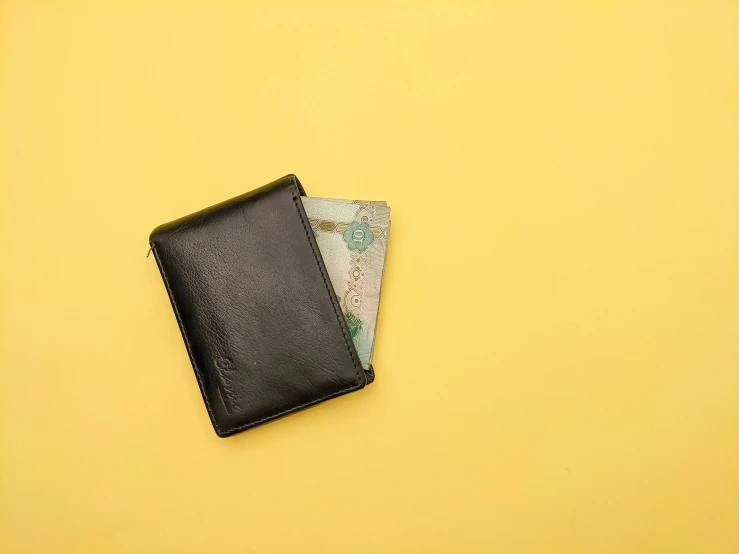 a black wallet sitting on top of a yellow background, by Niko Henrichon, pexels contest winner, square, banknote, maxim shirkov, small