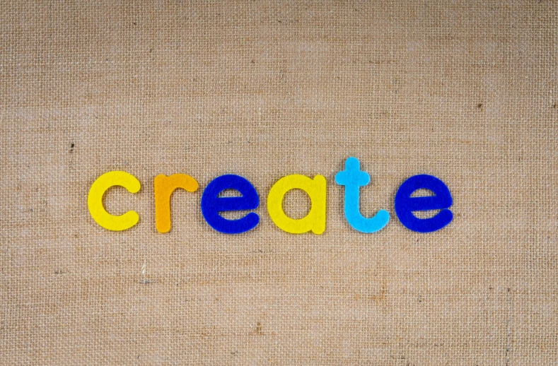 the word create spelled out of plastic letters, inspired by Dirk Crabeth, pexels, yellow and blue color scheme, on a canva, sustainable materials, design your own avatar