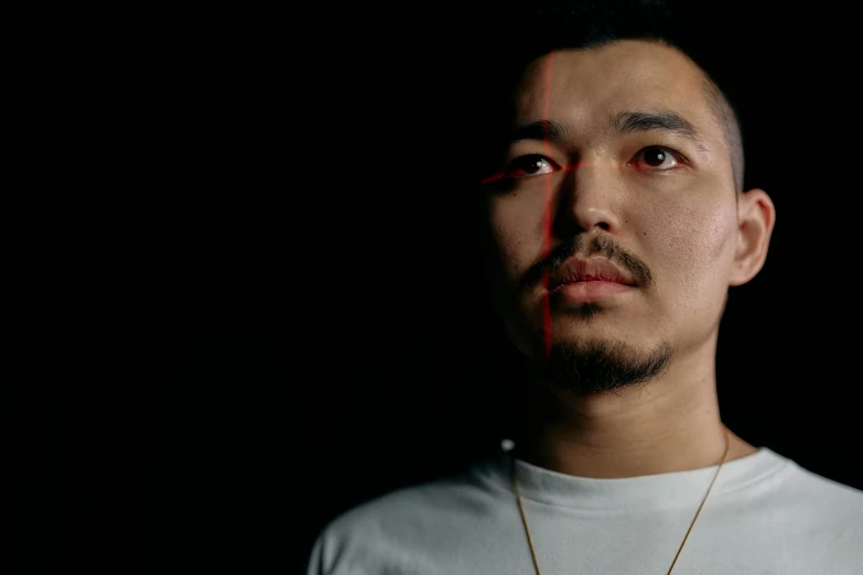 a man standing in front of a black background, inspired by Zhu Da, hyperrealism, promotional image, long chin, shot on 1 5 0 mm, portrait of a crying ai artist