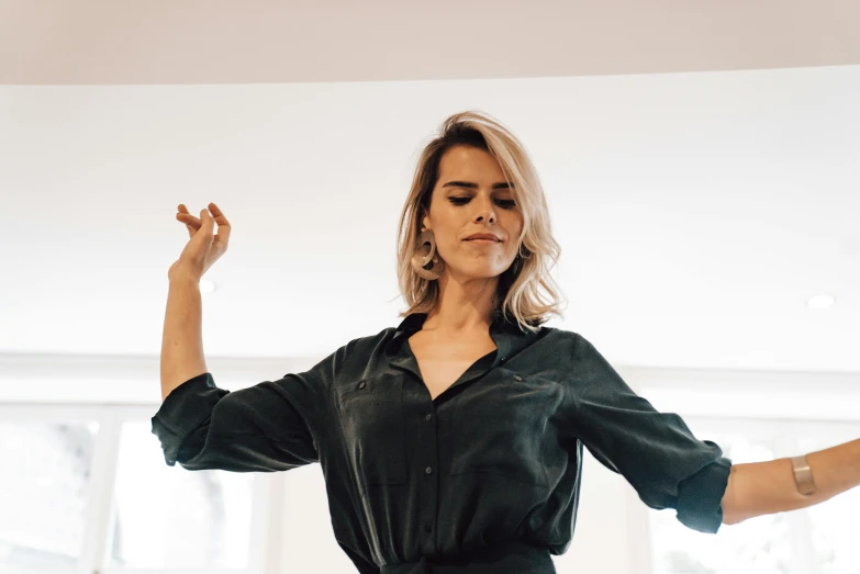 a woman in a black dress is dancing, an album cover, trending on pexels, gorgeous female samara weaving, morning mood, wearing a shirt, frantic dancing pose