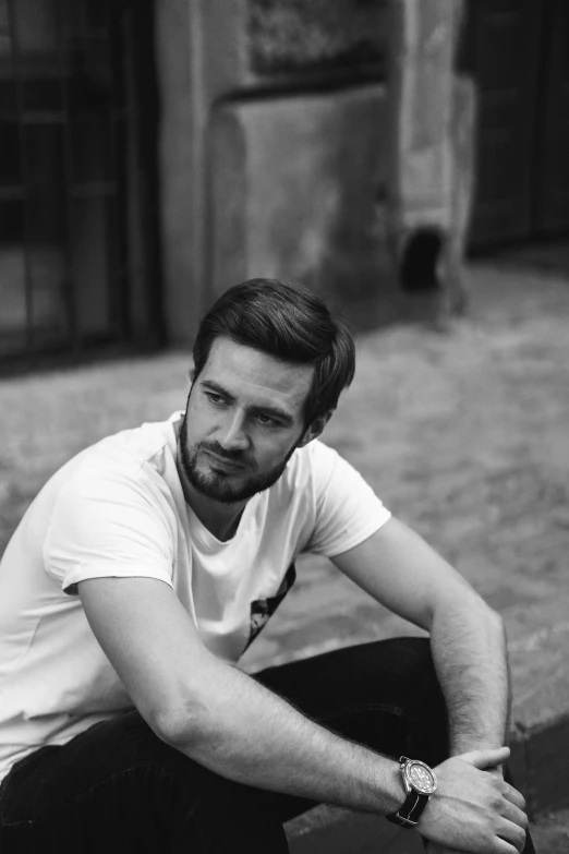 a black and white photo of a man sitting on a curb, man in white t - shirt, luka mivsek, beard stubble, ::