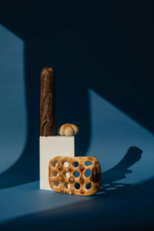 a cigar sitting on top of a wooden block, an abstract sculpture, inspired by Joris van der Haagen, breads, an intricate, cellular, low-contrast