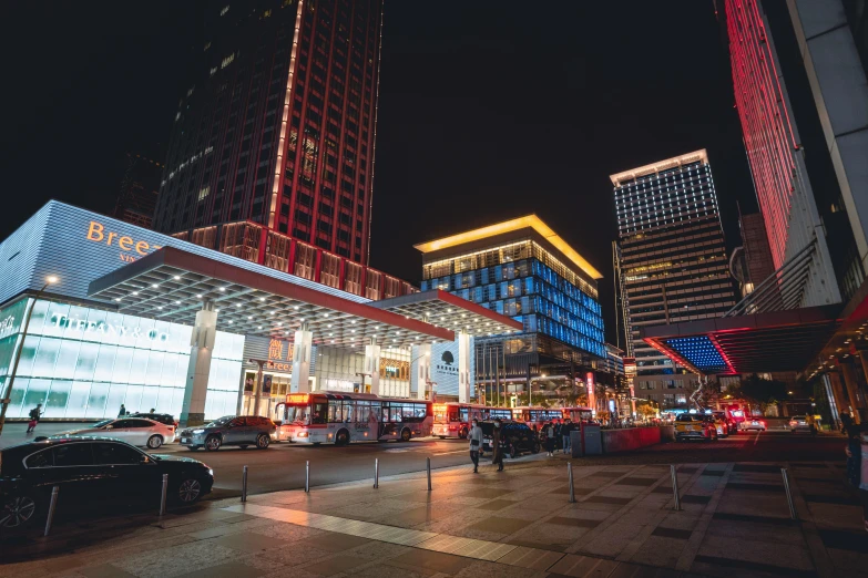 a city street filled with lots of traffic next to tall buildings, blue and red lighting, baotou china, dark city bus stop, thumbnail