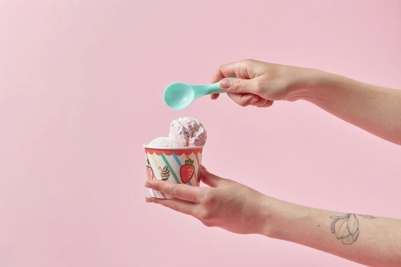 a close up of a person holding a cup of ice cream, teal and pink, product shot, spoon, small