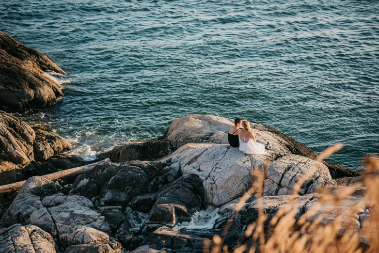 a man sitting on top of a rock next to the ocean, unsplash, happening, wedding, 2 5 6 x 2 5 6 pixels, jordan grimmer and natasha tan, manly